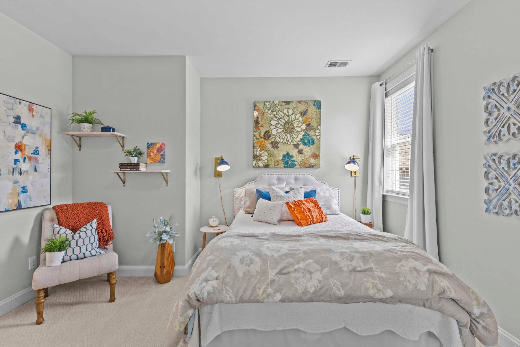 Guest bedroom in soft sage with warm orange and blue accents