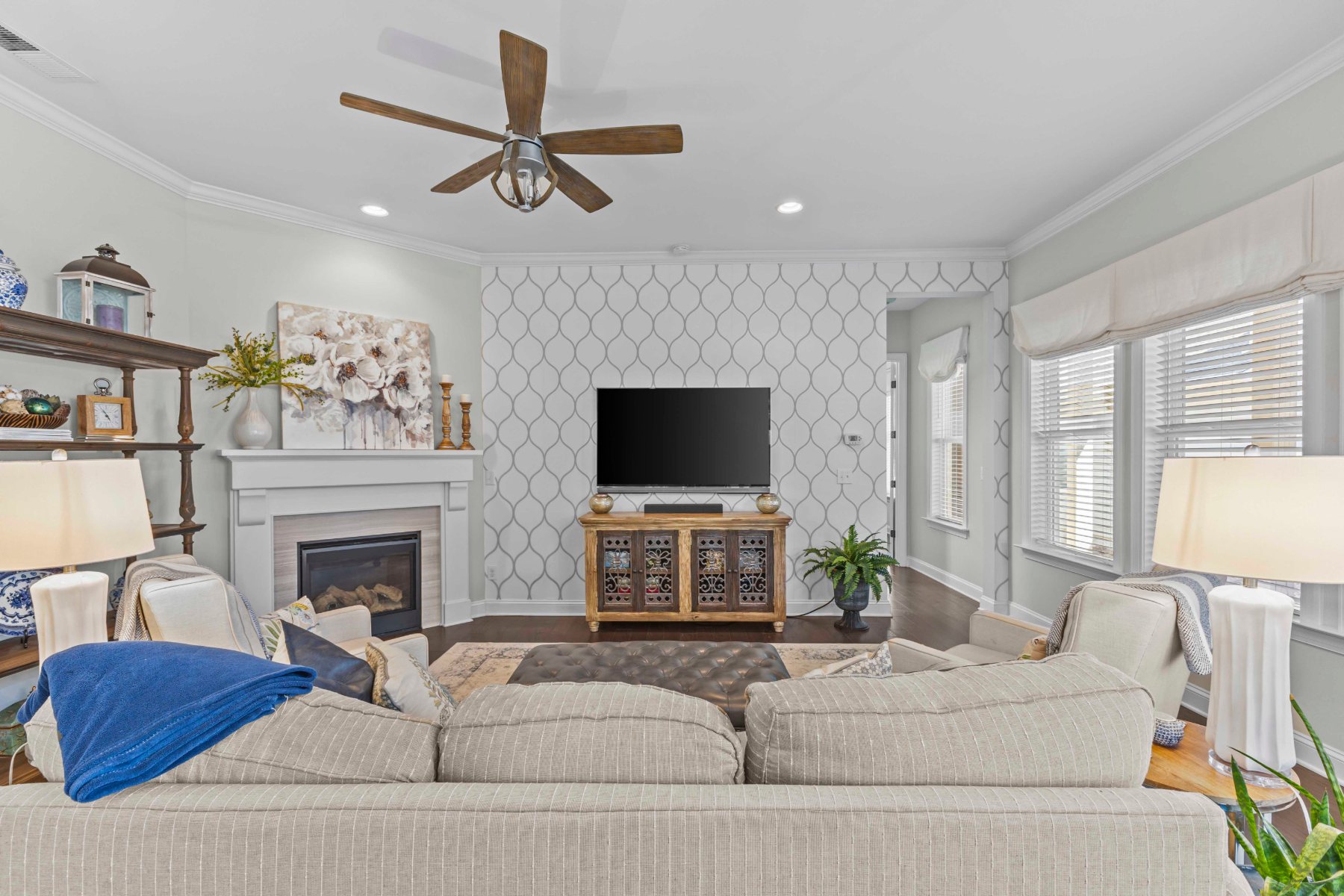 Family room with fireplace, patterned accent wall, and layered seating