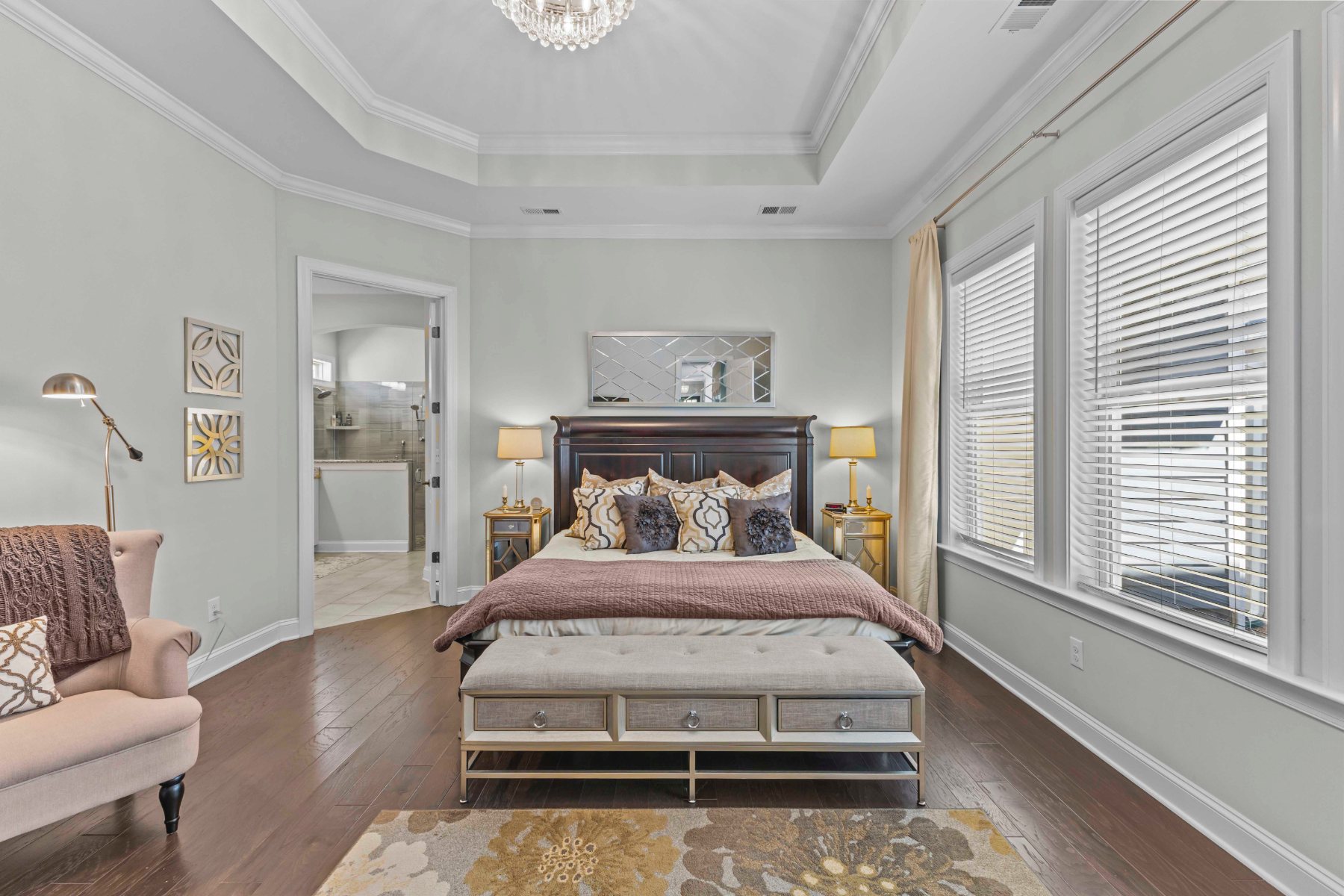 Primary bedroom with tray ceiling, dark wood bed, and mauve bedding