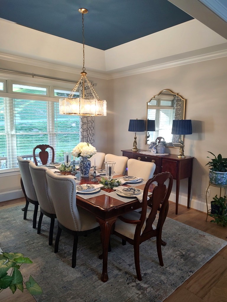 Formal dining room with a deep-blue tray ceiling, gold drum chandelier, and blue-and-white porcelain