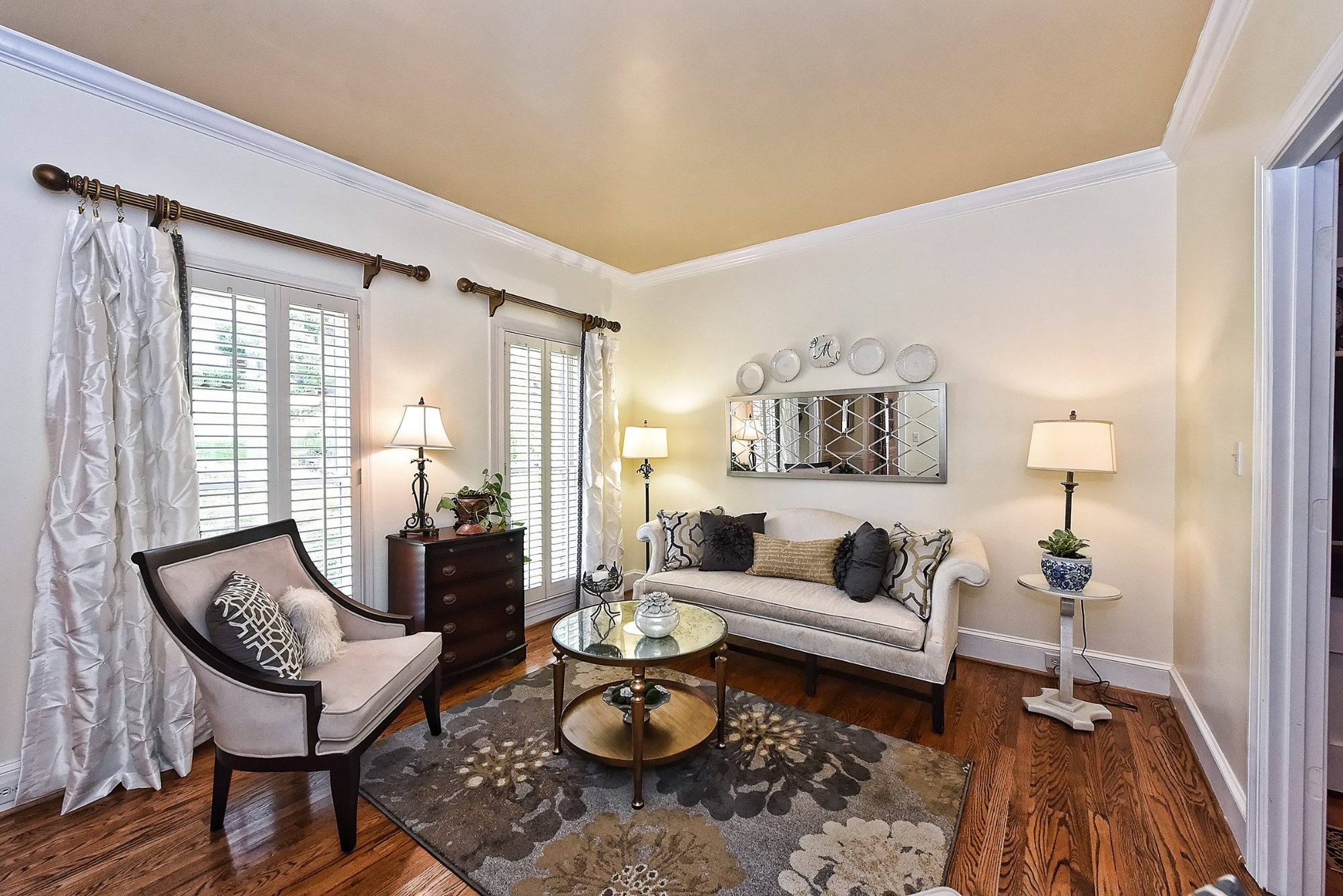 Formal living room with silk drapery, camelback sofa, and a hand-finished gold ceiling